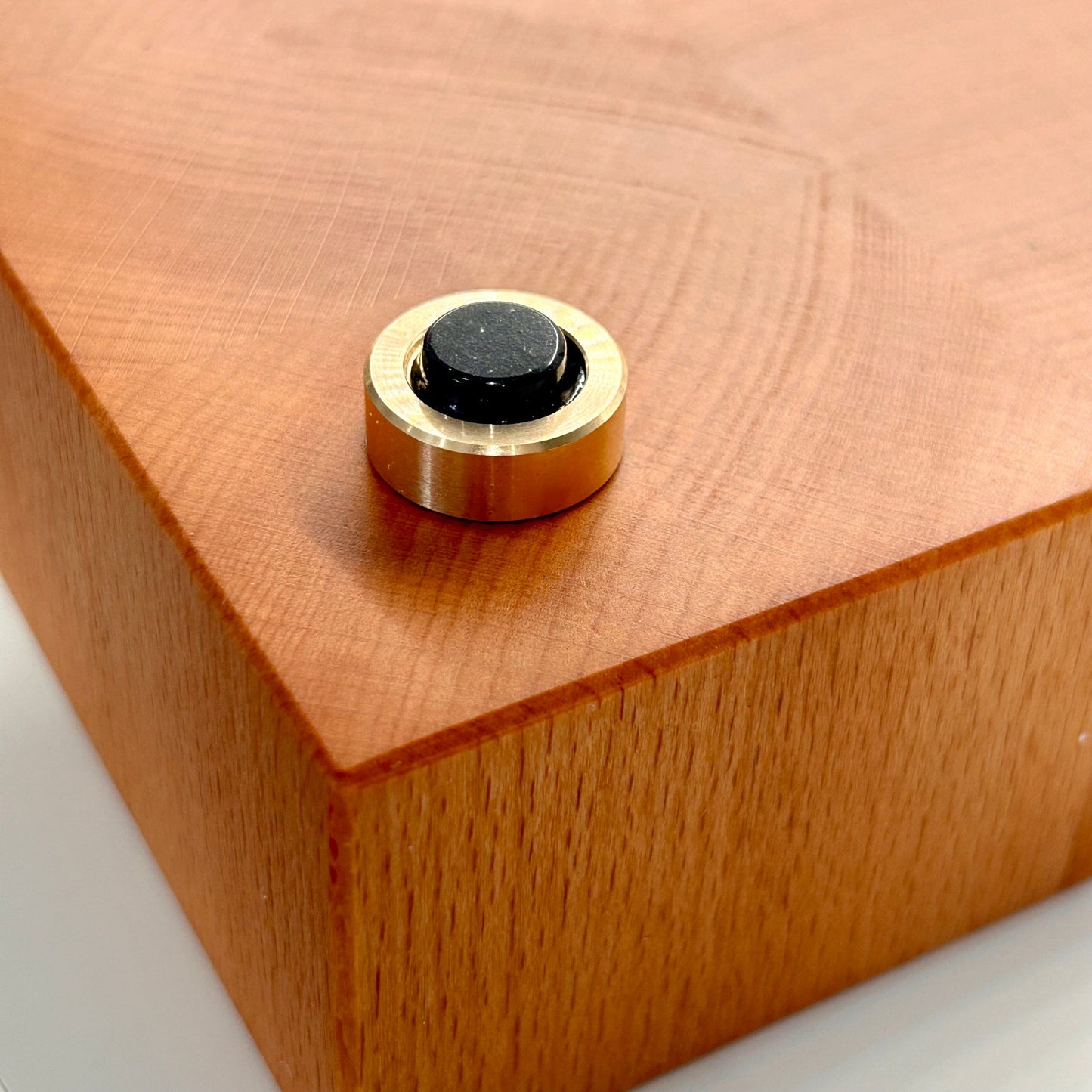 Zoom sur un pied en laiton massif avec patin antidérapant d’une grande planche à découper artisanale en bois de bout en hêtre