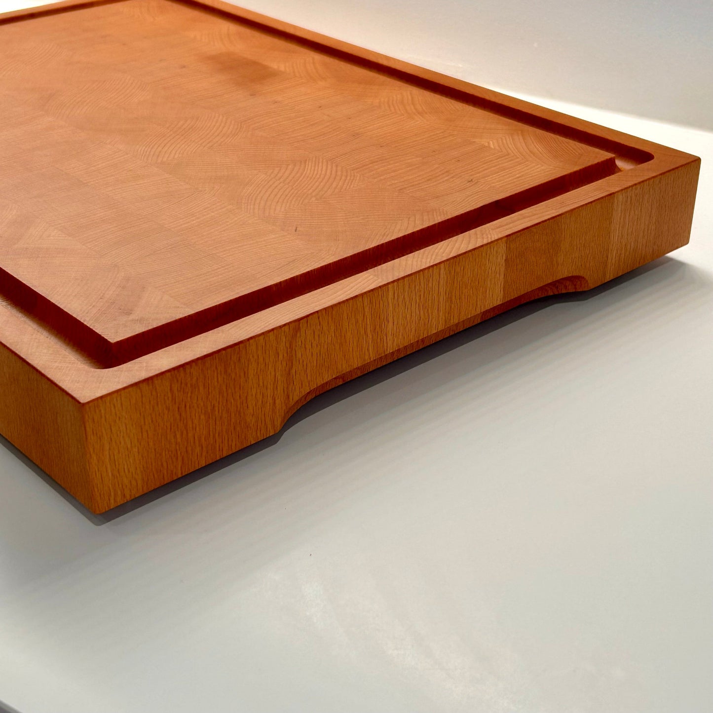 Vue de côté d’une grande planche à découper en bois de bout en hêtre artisanale