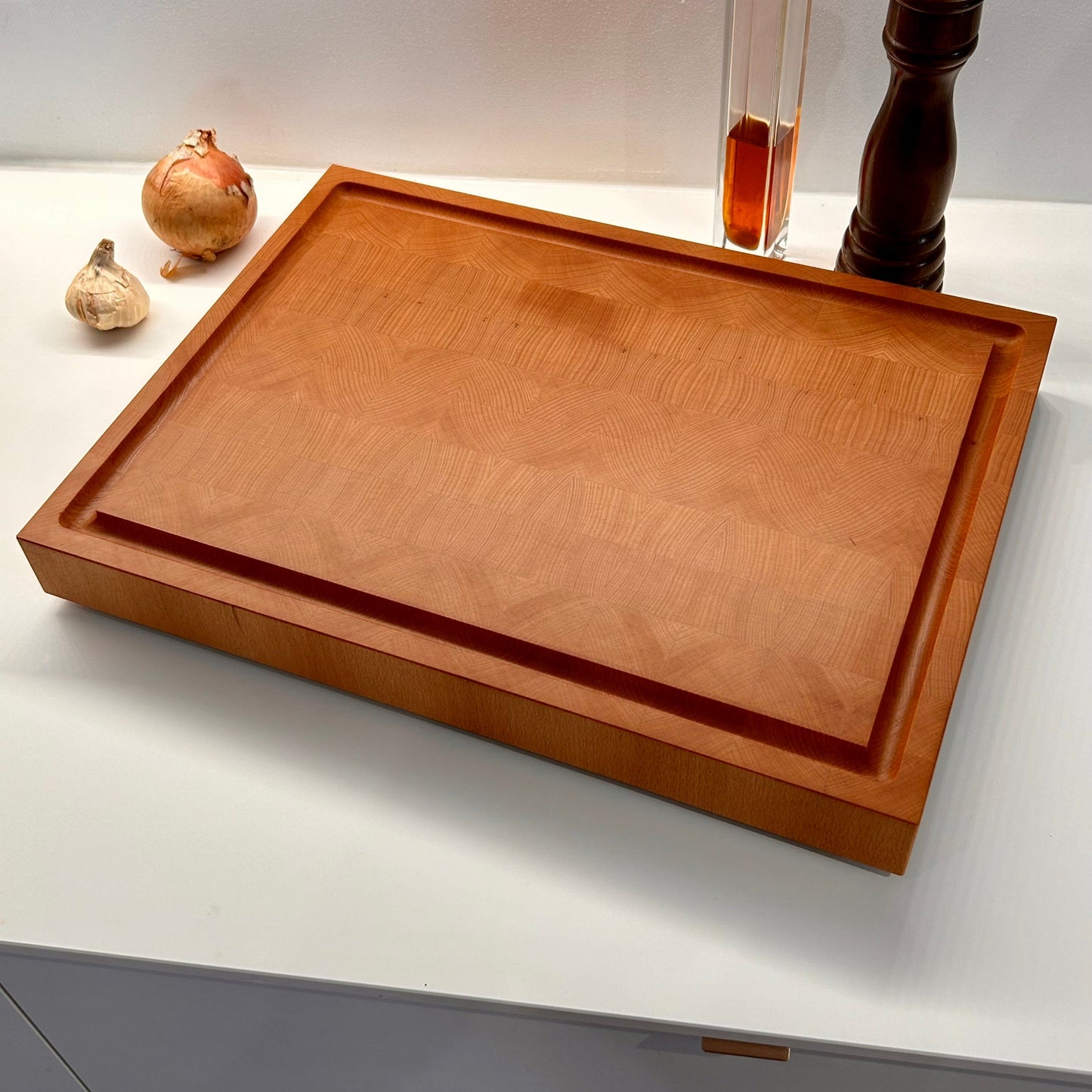 Mise en situation d’une grande planche à découper en bois de bout en hêtre sur un plan de travail de cuisine