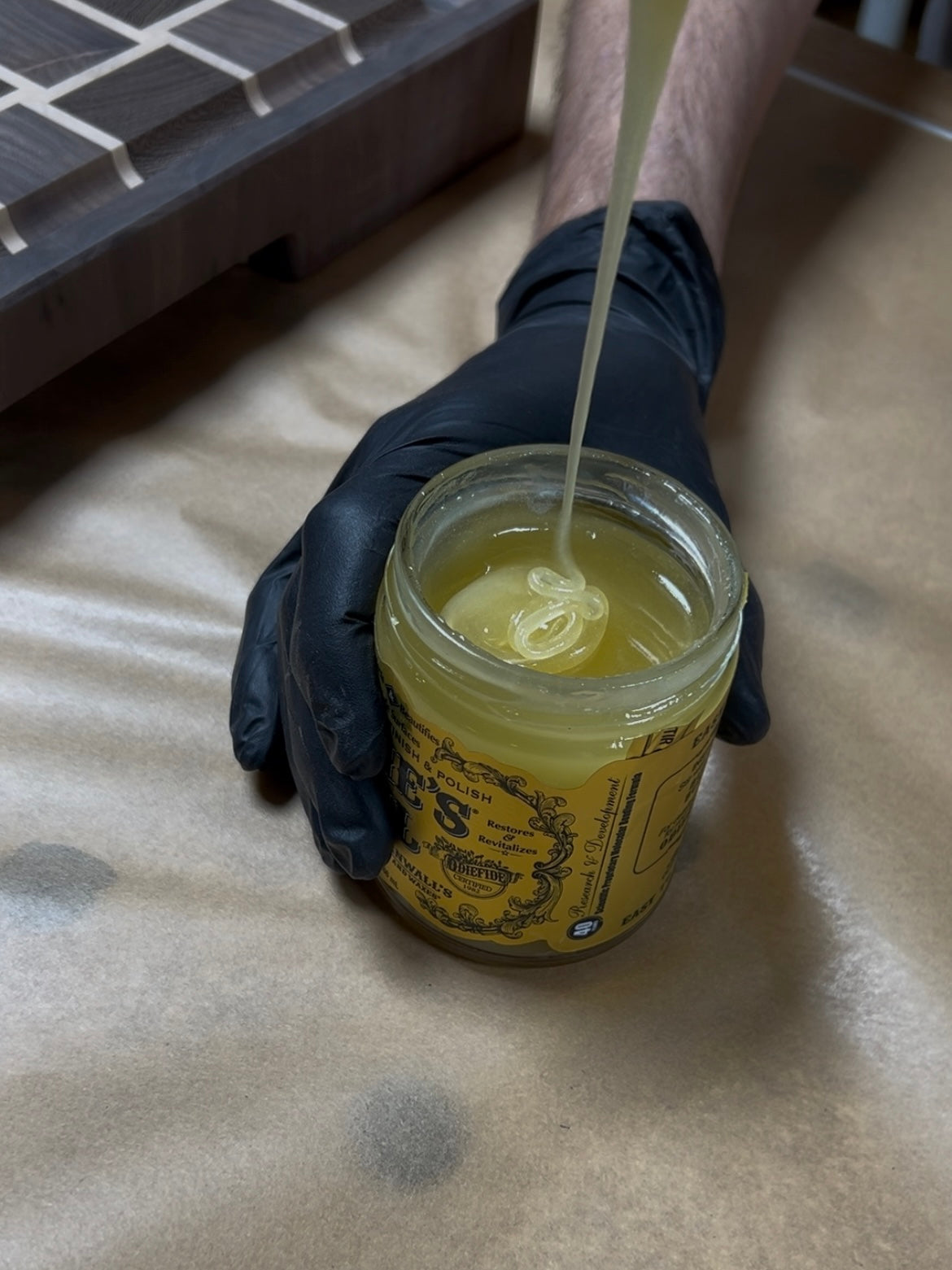 Détail d'un pot d'huile naturelle pour la finition d'une planche à découper artisanale