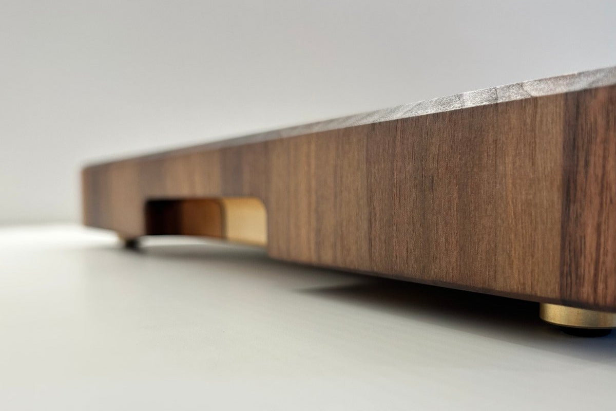 Profil d'une planche à découper artisanale Made in France en noyer avec pieds en laiton massif