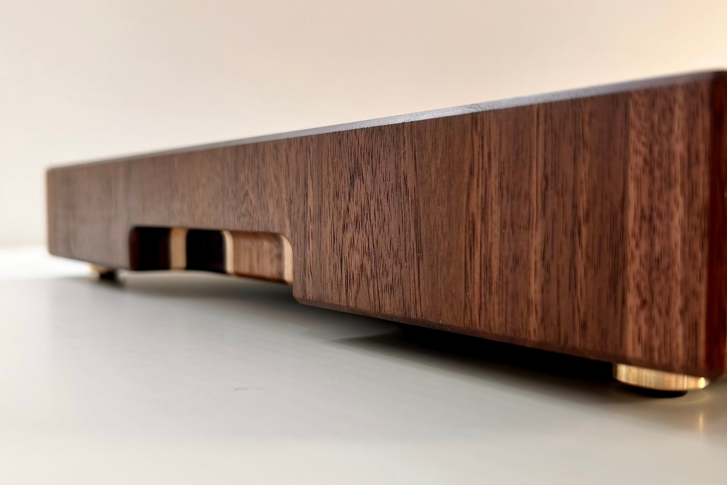 Vue de l'épaisseur d'une planche à découper artisanale en bois de bout, révélant une construction robuste de 50 mm. Conçue en noyer américain, wengé et érable clair, avec des finitions haut de gamme, elle offre durabilité, stabilité et résistance aux usages intensifs.
