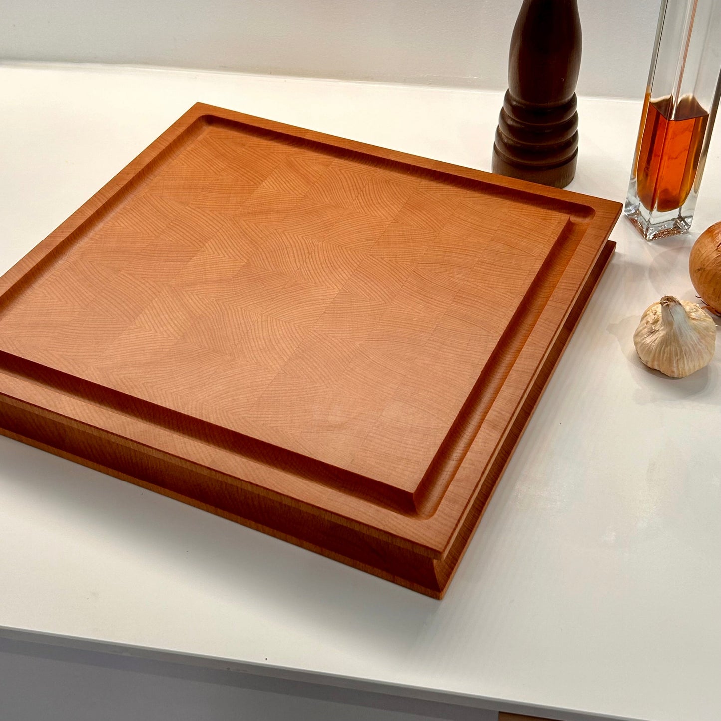 Planche à découper en bois de bout en hêtre, rigole à jus et mise en situation dans une cuisine