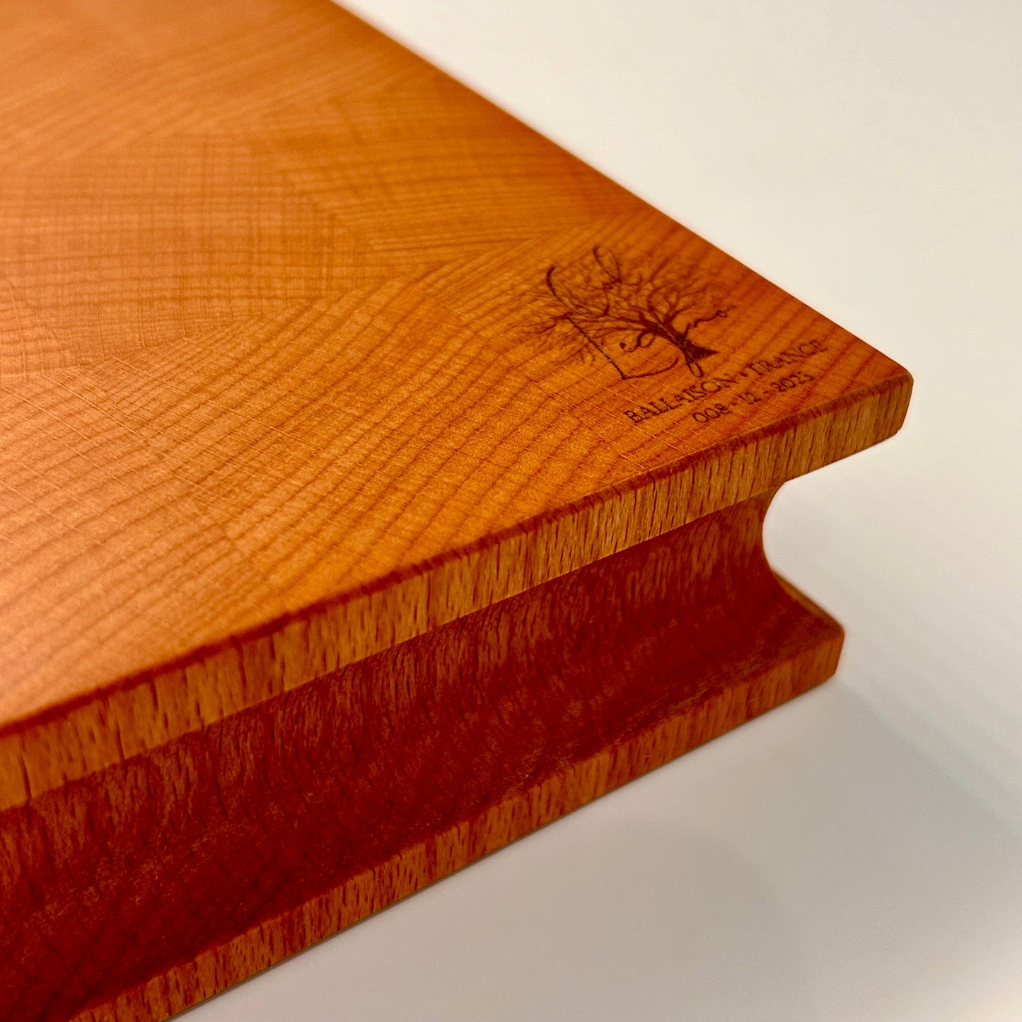 Détail du coin et du logo Col Legno gravé sur une planche en bois de bout en hêtre épaisse.
