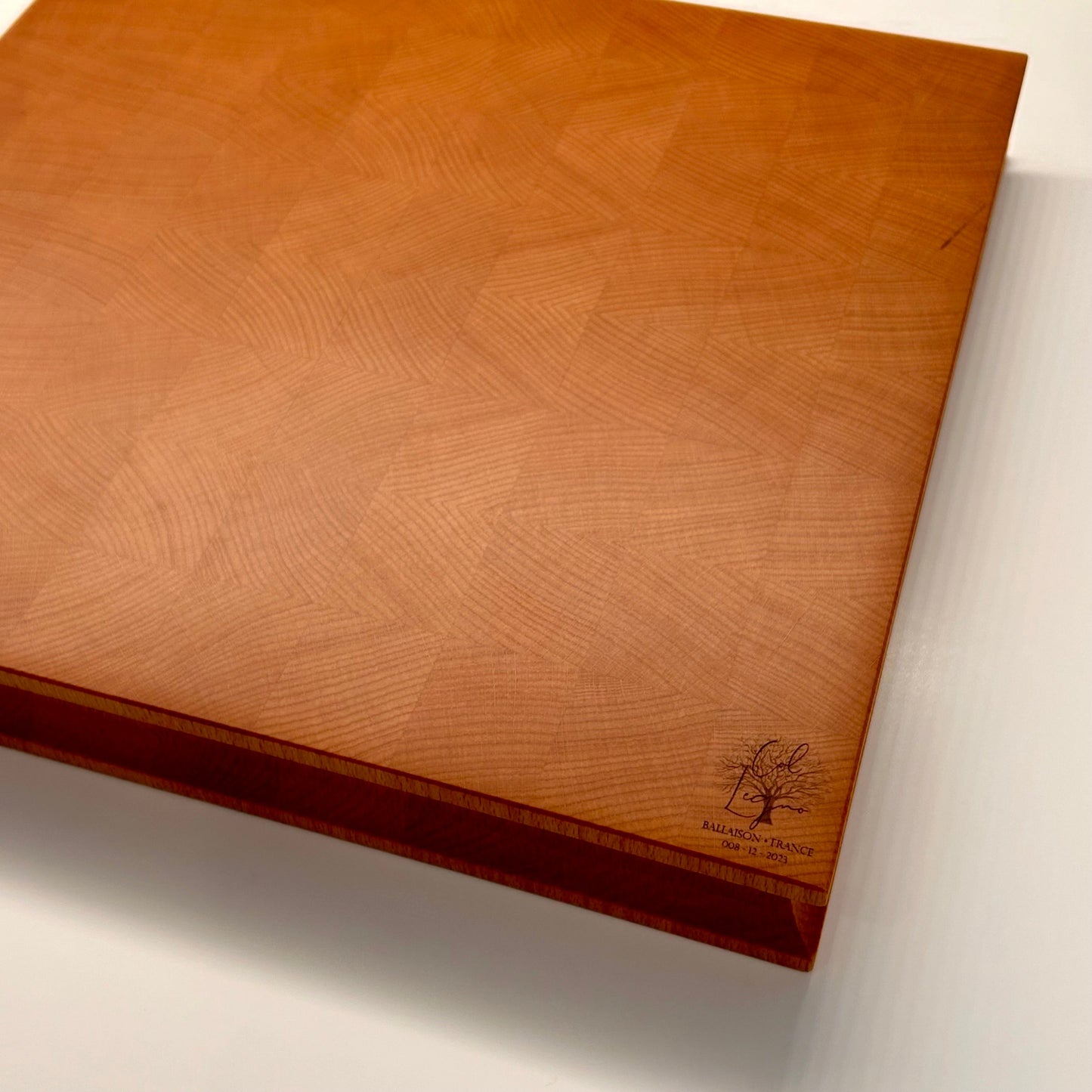 Vue de dessous d’une planche en bois de bout en hêtre, avec surface lisse et lustrée, logo Col Legno gravé et cernes naturels du bois visibles.