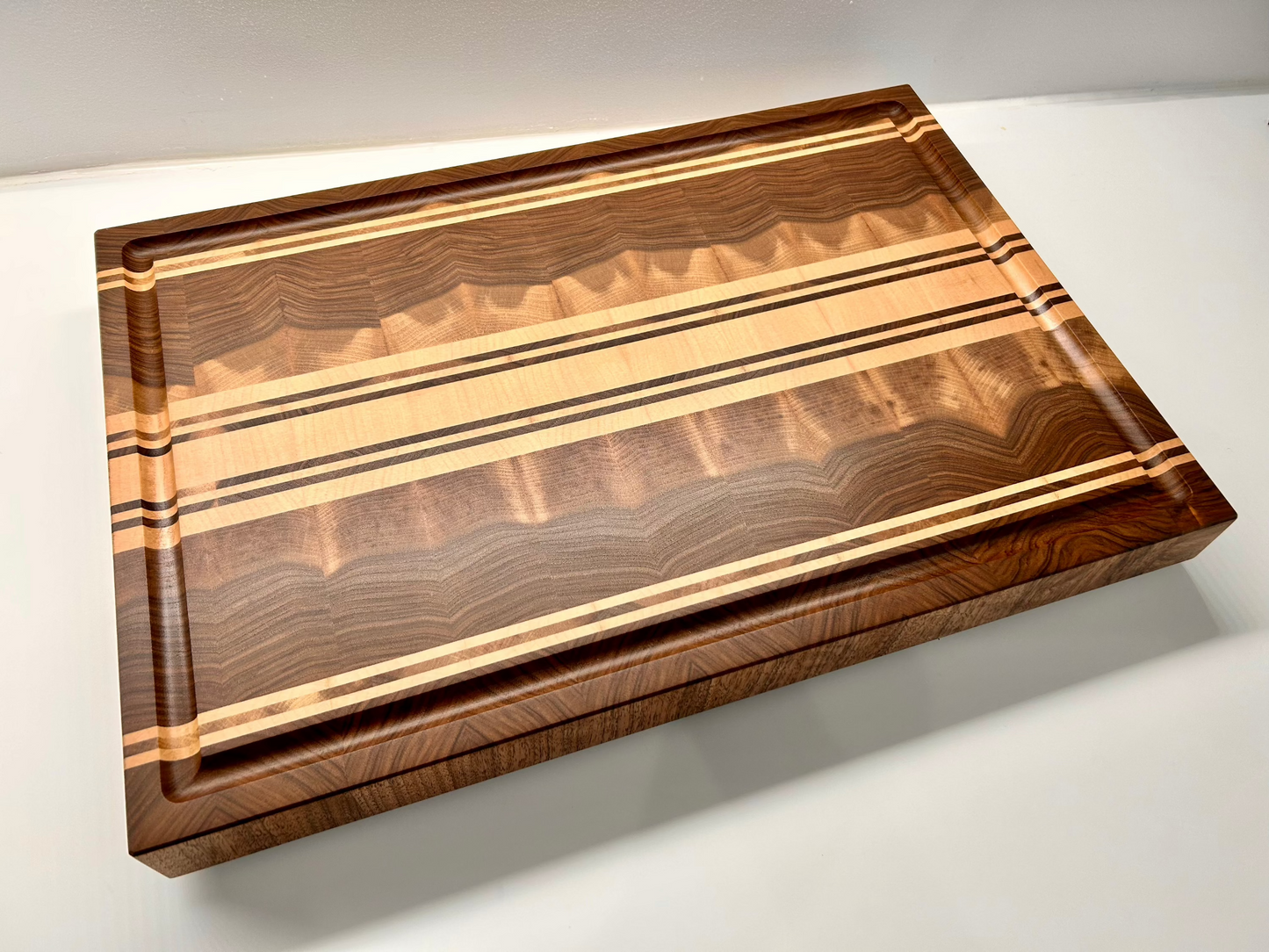 Vue globale d'une planche à découper artisanal en noyer français et érable, fabriquée en France