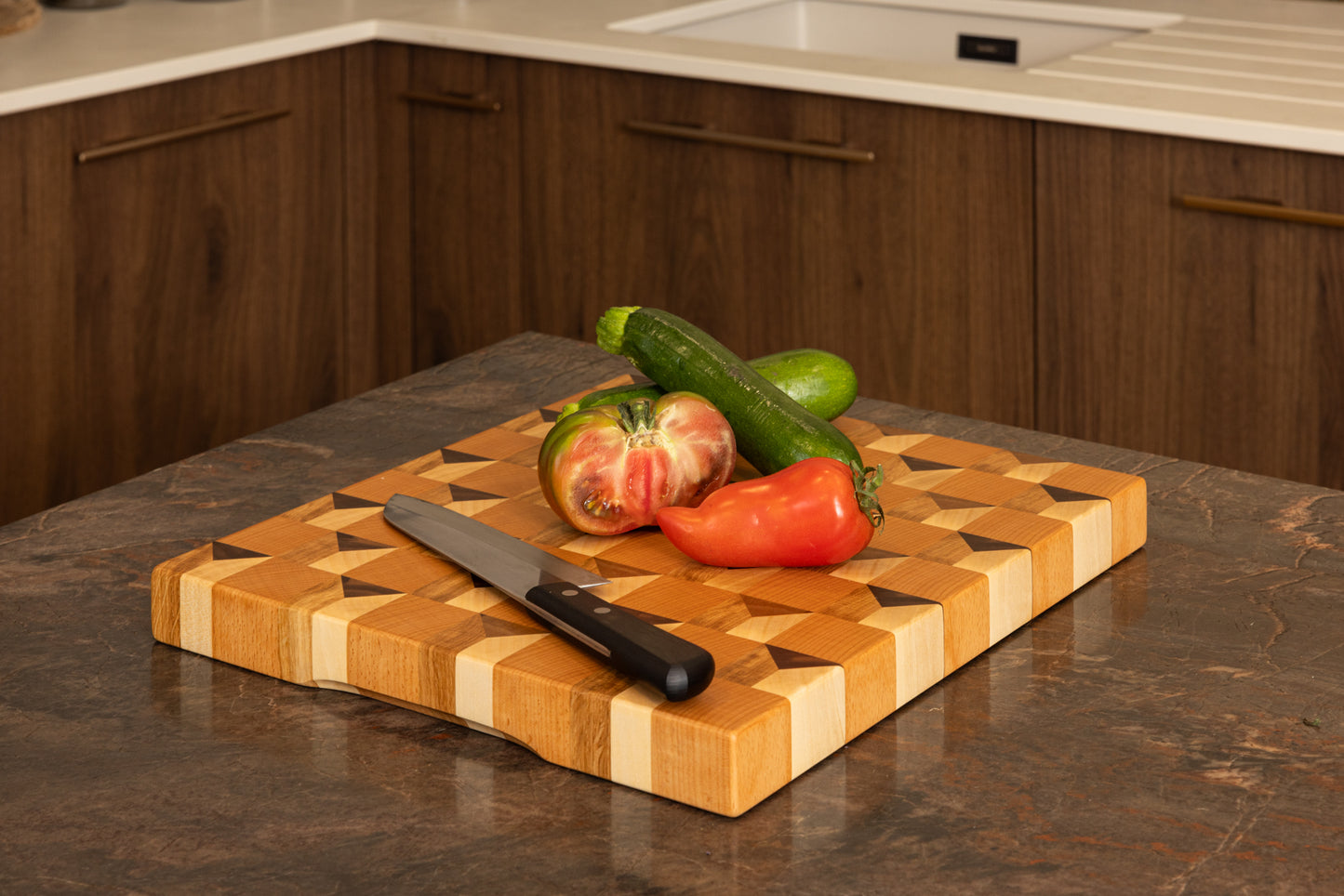 Planche à découper 3D Cube en bois de bout, présentée dans une cuisine haut de gamme avec plan de travail en granit, légumes frais et couteau de chef, artisanat français de luxe.