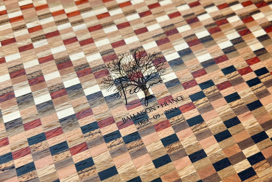 Détail du logo gravé au dos d’une planche à découper artisanale en bois massif. Finition soignée, design haut de gamme fabriqué en France.