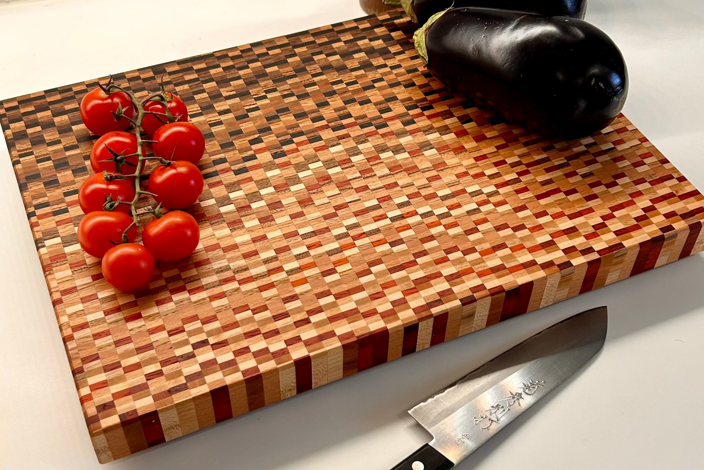 Planche à découper artisanale en bois massif utilisée en cuisine avec légumes et couteau. Design moderne, pratique et haut de gamme.