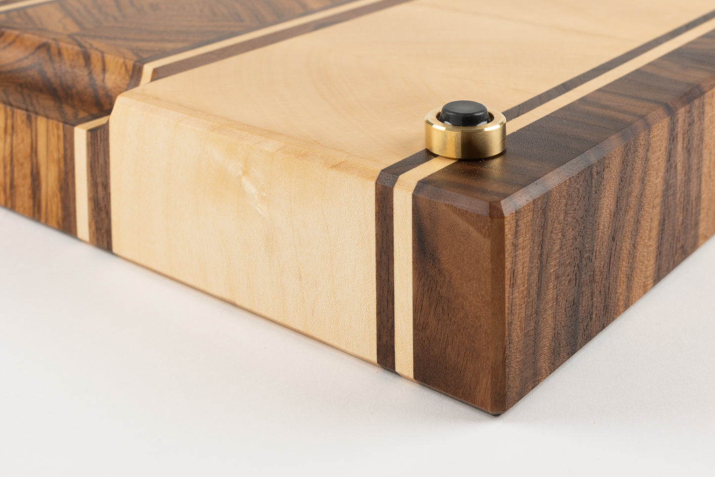 Détail du pied en laiton massif fabriqué en France, intégré à la planche à découper artisanale Couperin en bois massif, alliance de matériaux nobles et finitions haut de gamme
