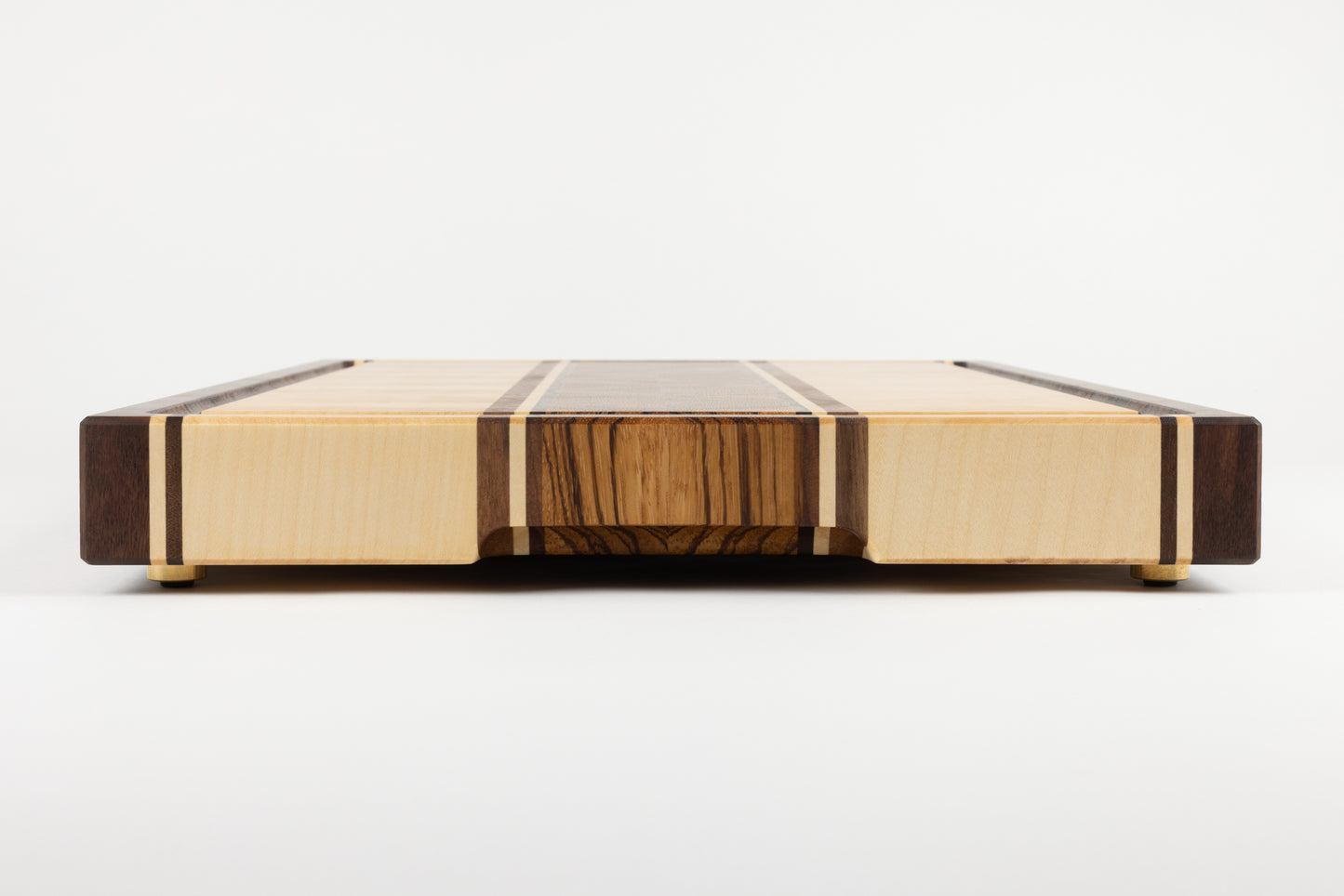 Planche à découper artisanale modèle Couperin, vue de côté, mettant en avant le détail soigné de la poignée en bois massif, alliant ergonomie et design élégant