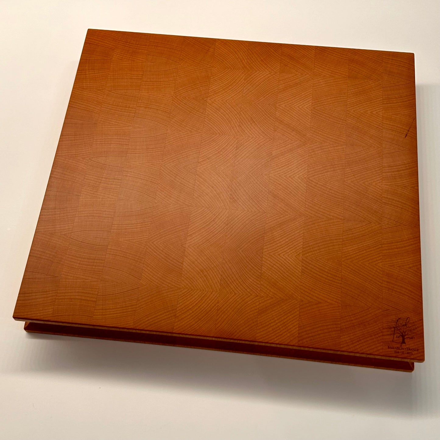 Vue globale de dessous d’une planche en bois de bout en hêtre, avec surface lisse finement lustrée à la cire d’abeille et veinage disposé en miroir.