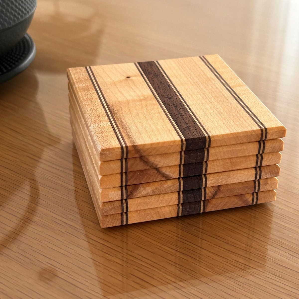 Sous-verres en bois d’érable et noyer, élégants et minimalistes, avec une finition huilée naturelle.