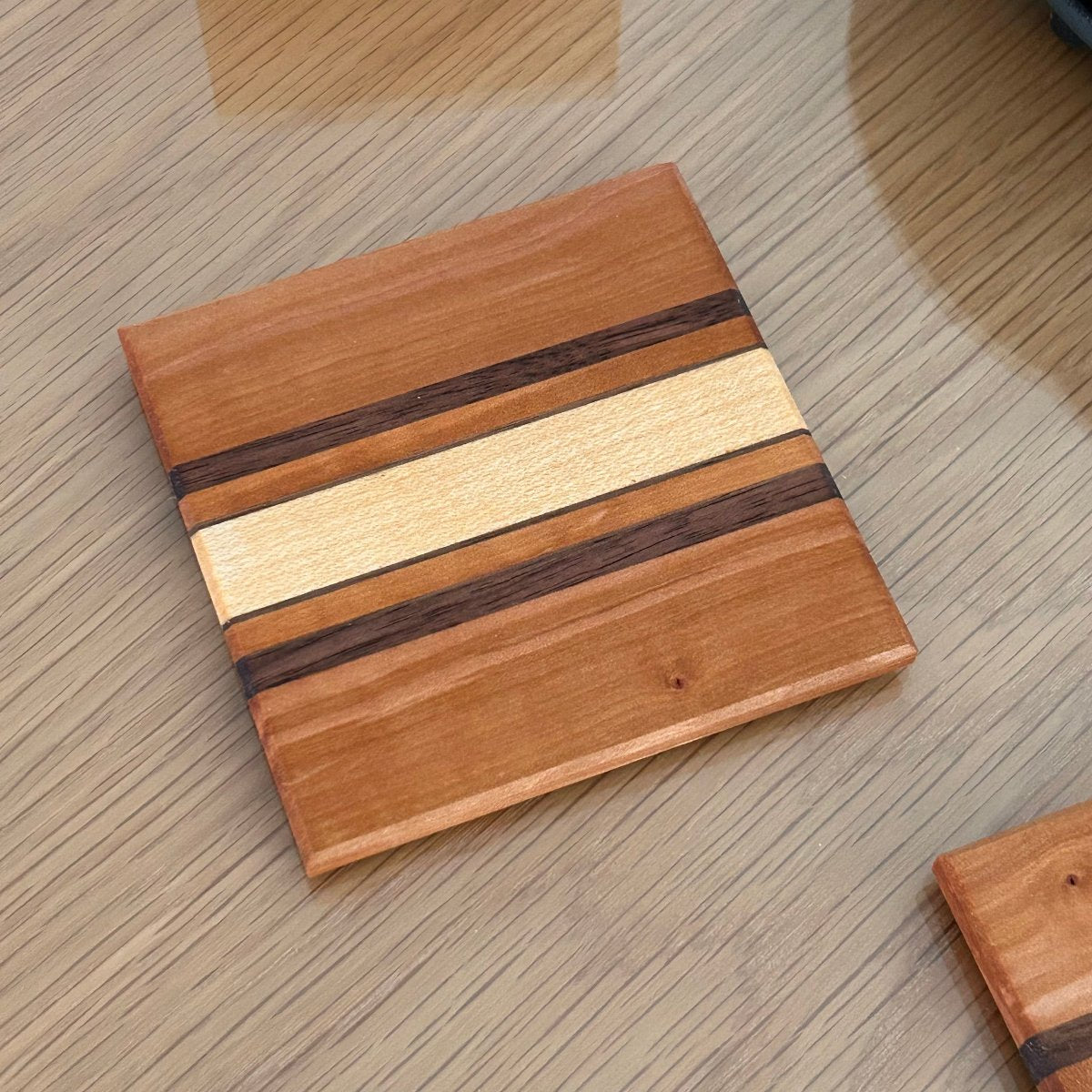Sous-verres Made in France en bois de poirier, design intemporel avec rayures fines et finition naturelle.