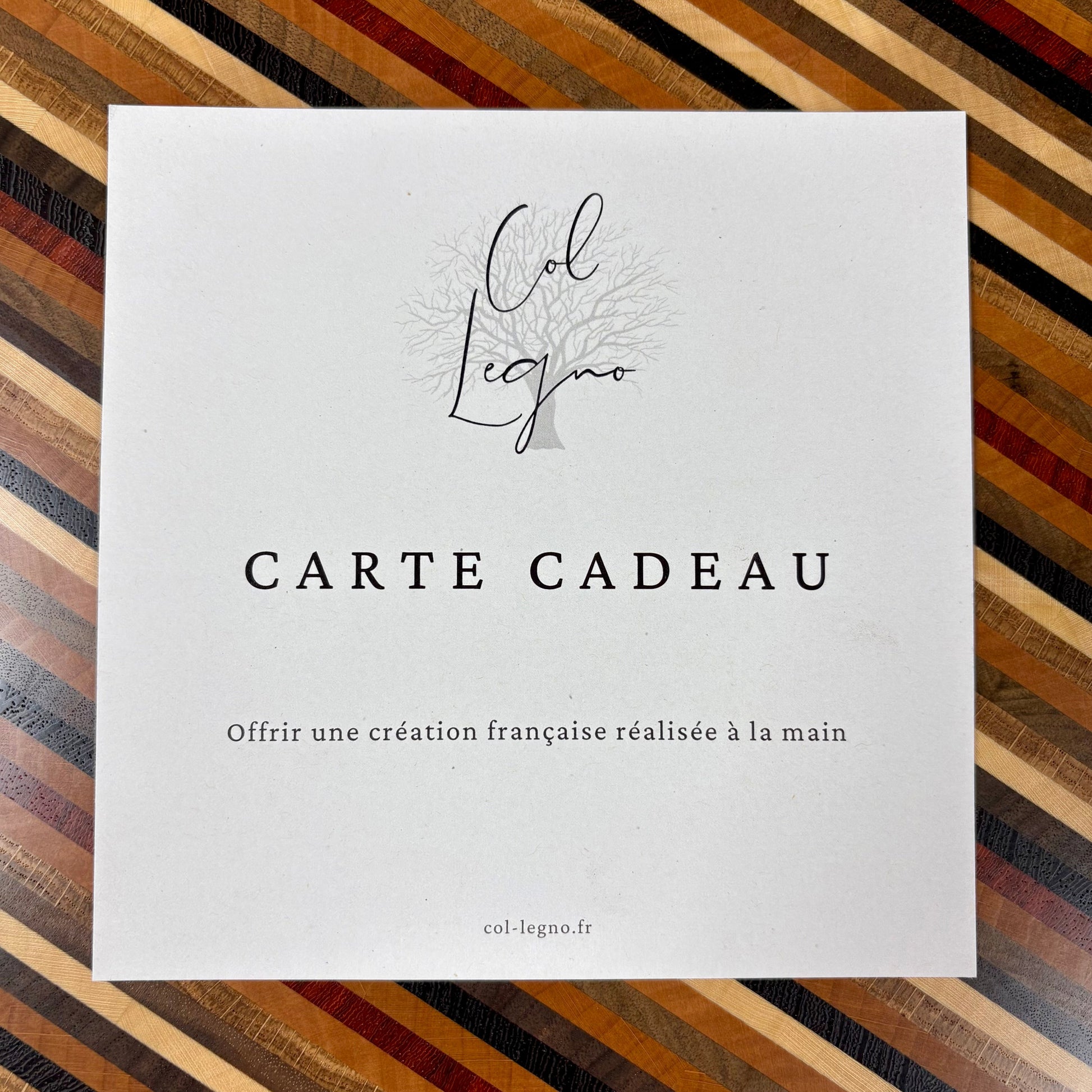 Carte cadeau Col Legno posée sur une planche à découper artisanale en bois massif, idée cadeau made in France.