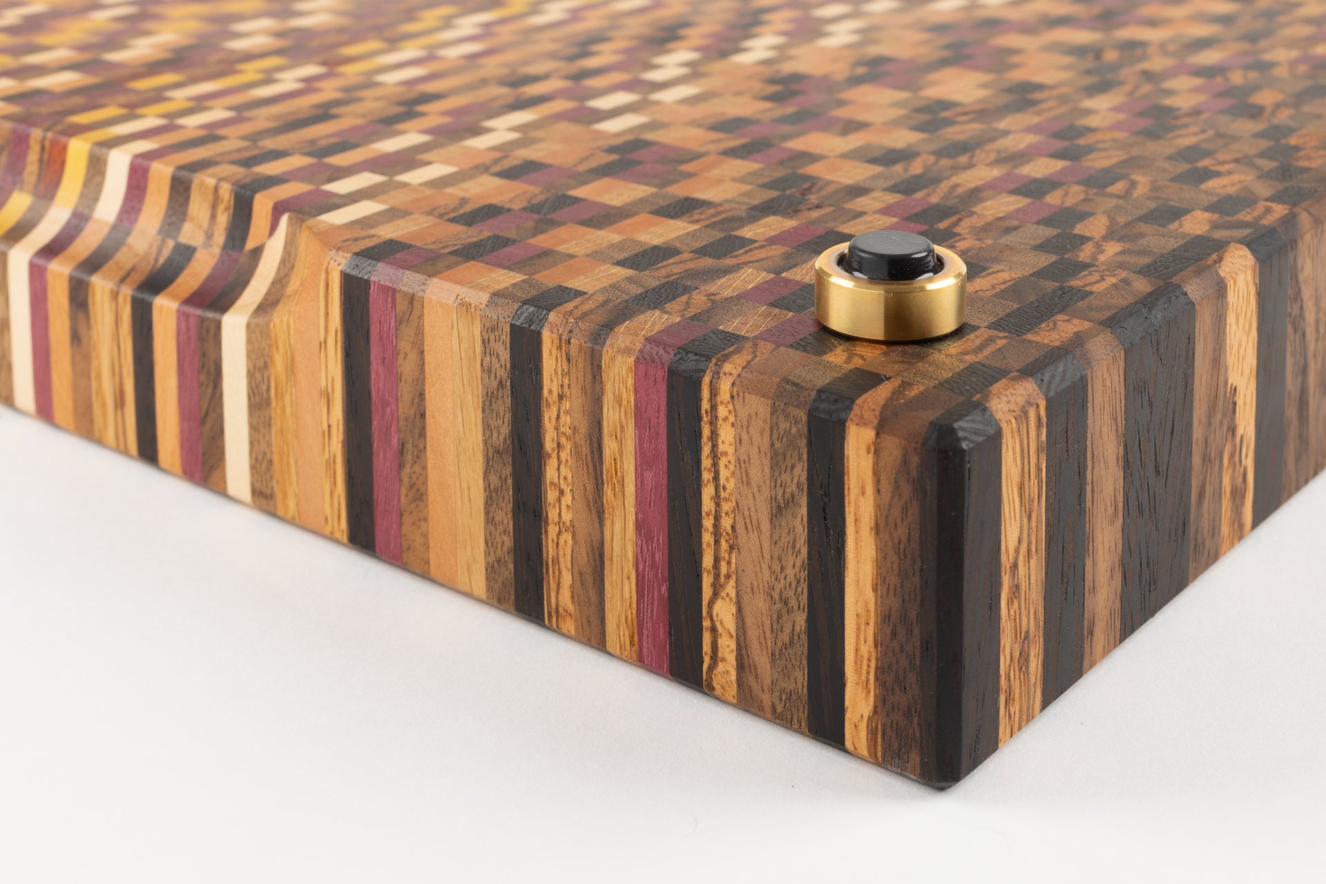 Gros plan sur le pied en laiton madein France d'une planche à découper artisanale haut de gamme.