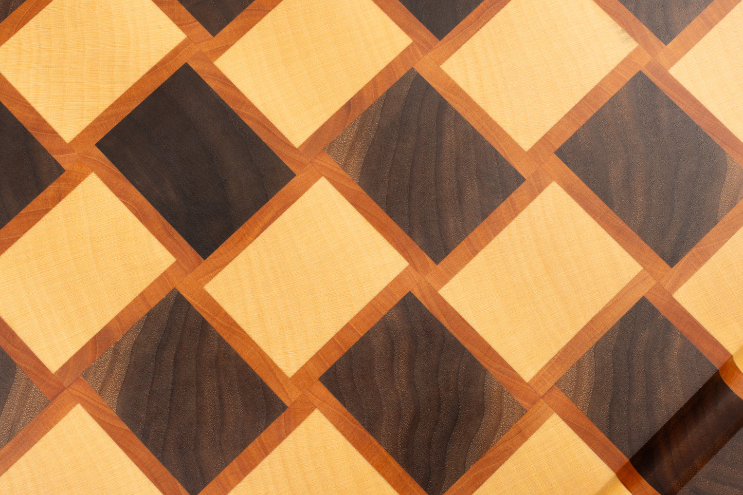 Gros plan sur une planche à découper artisanale en bois de bout avec motif damier, fabriquée en érable, poirier et noyer américain massif, design haut de gamme.