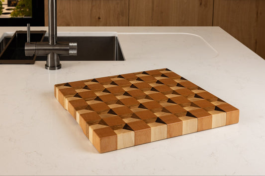 Planche à découper artisanale en trompe l’œil 3D, bois de bout chêne, noyer hêtre et érable, sur le plan de travail blanc d'une cuisine moderne en chêne
