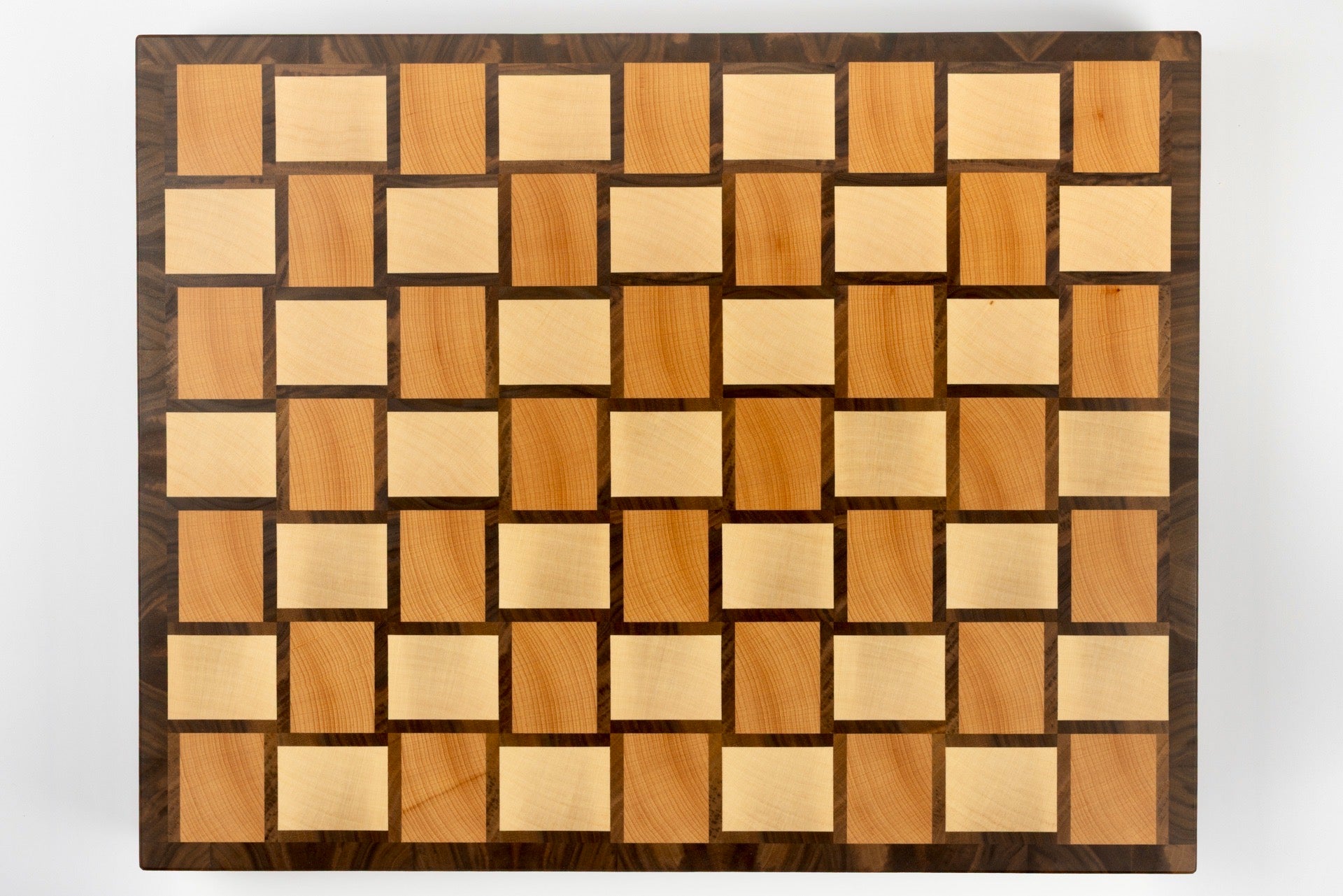 Vue de dessus de la planche à découper Berlioz, design graphique à damier tissé en bois de bout multi-essences, érable, noyer américain et hêtre, fabrication artisanale française haut de gamme.
