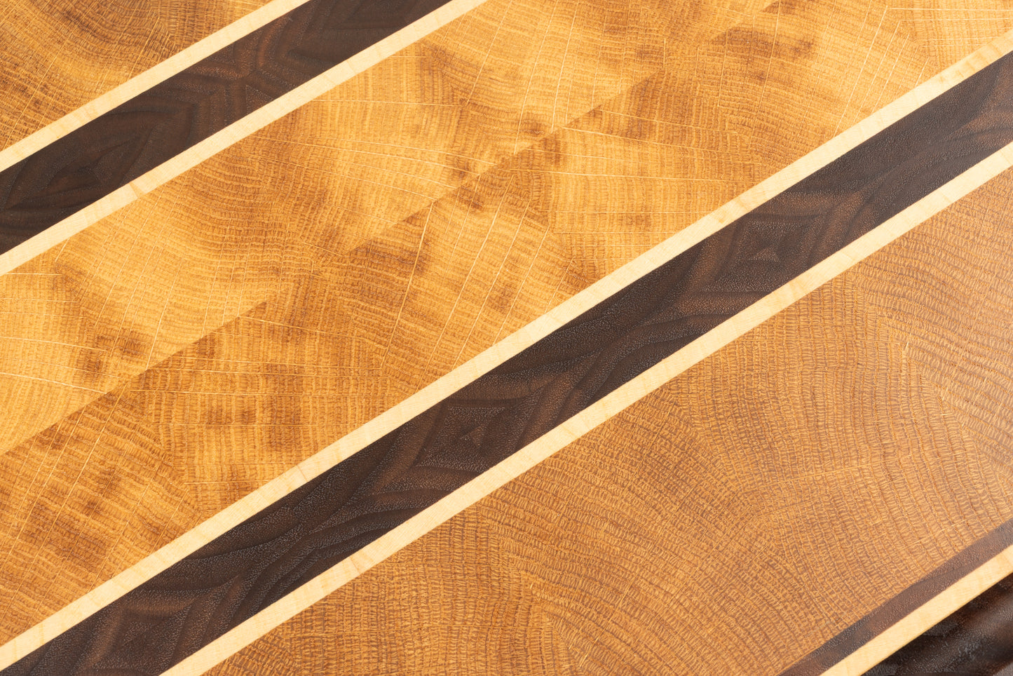 Planche à découper de luxe en bois de bout Ravel, gros plan sur le motif en diamant réalisé avec du chêne français, du noyer américain et de l’érable, veinage élégant et fabrication artisanale Made in France.