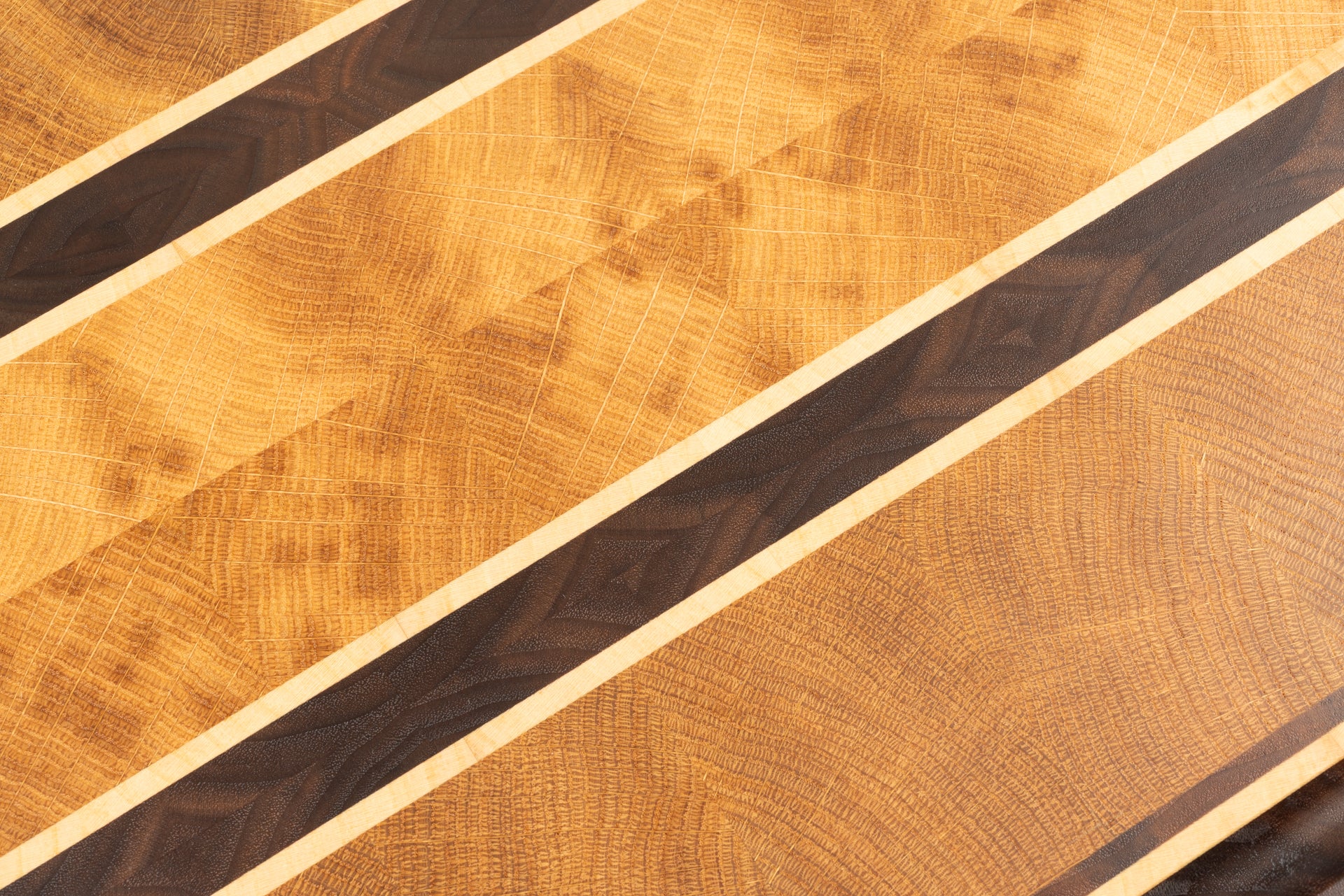 Planche à découper de luxe en bois de bout Ravel, gros plan sur le motif en diamant réalisé avec du chêne français, du noyer américain et de l’érable, veinage élégant et fabrication artisanale Made in France.