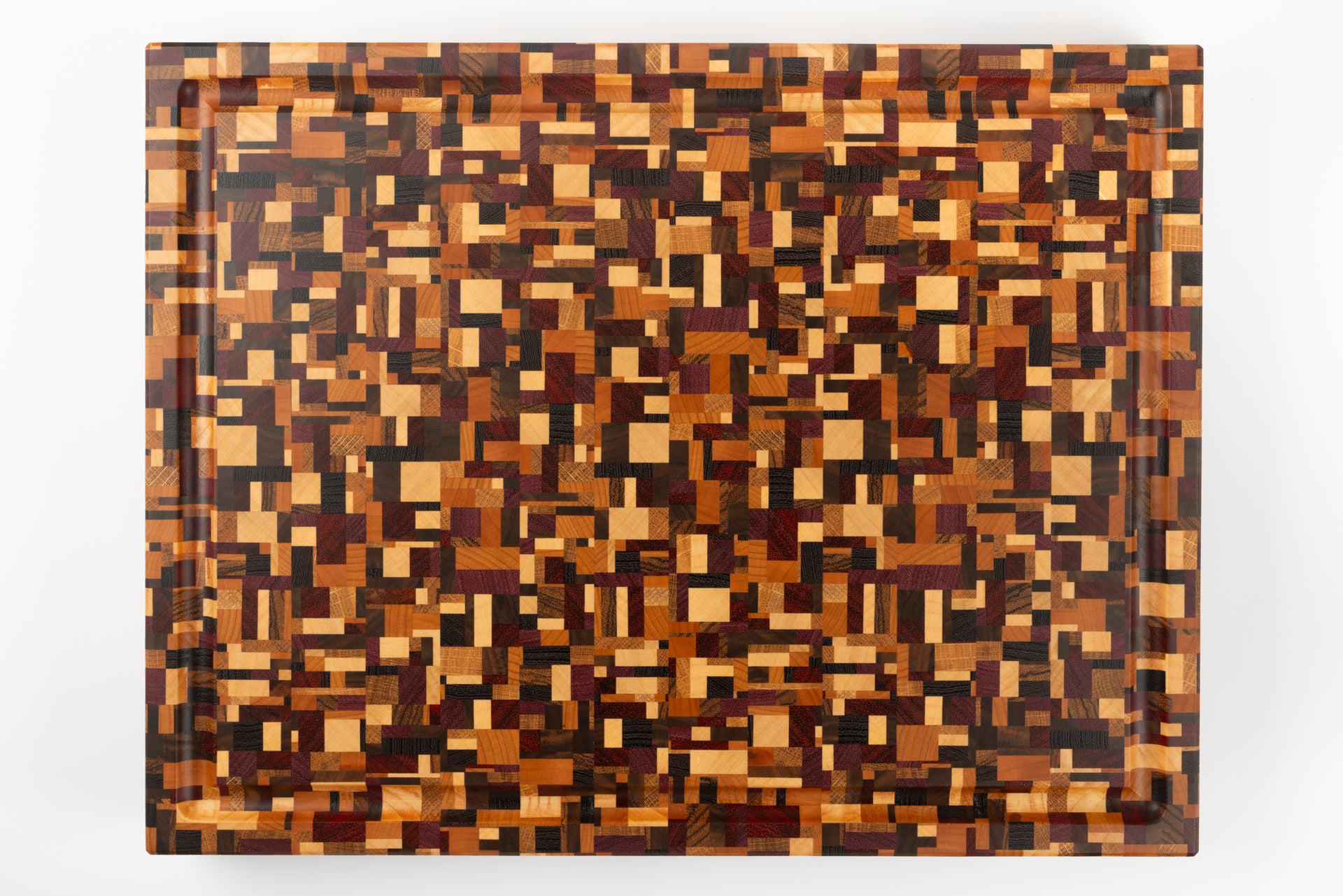 Planche à découper de luxe Messiaen, vue de dessus révélant son design unique en 9 essences de bois précieux, création haut de gamme Made in France.